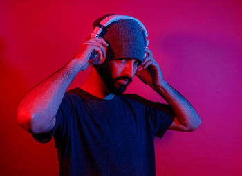 Man wearing hat against red background