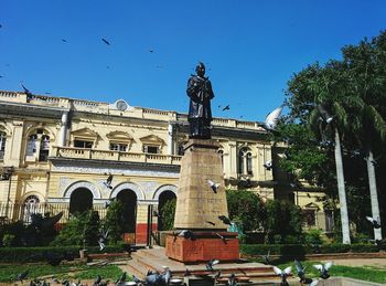 Low angle view of statue against clear blue sky