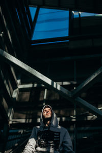 Portrait of young man standing on railing