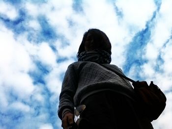 Low angle view of people against cloudy sky