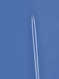 Low angle view of airplane flying against blue sky