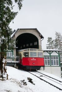 Train on snow covered railroad tracks against sky
