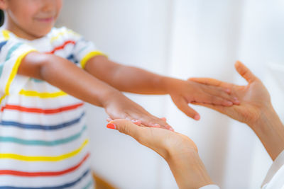 Physical medical exam for children. physical therapist doing medical exam, boy holding arms raised