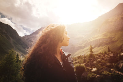 Young woman standing against mountains