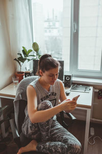 Woman using mobile phone at home