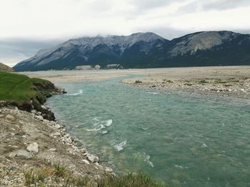 View of calm sea against mountain range