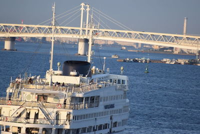 Suspension bridge over sea against clear sky