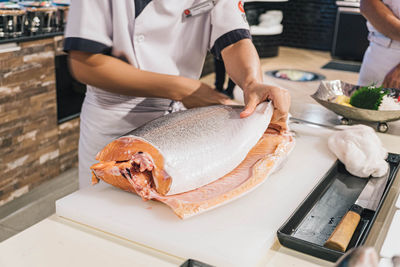 Midsection of woman holding food on table