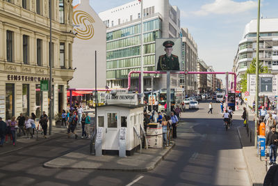 People on city street against buildings