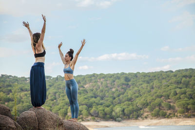 Full length of women standing on landscape against sky