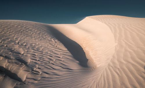 View of sand dunes in desert against sky