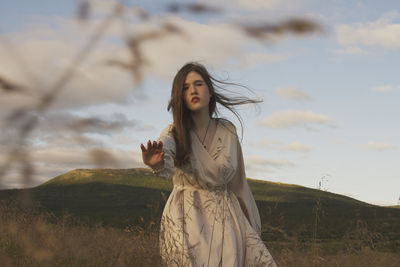 Woman standing on field against sky