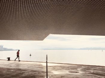 Man standing on sea shore against sky