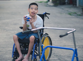 Full length of boy sitting on bicycle in city