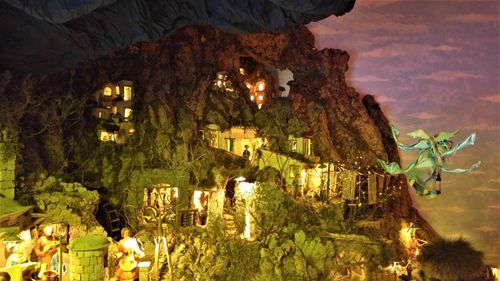 Panoramic view of illuminated building by cave