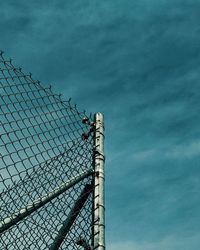 Low angle view of fence against sky