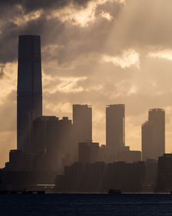 Modern buildings in city against sky during sunset