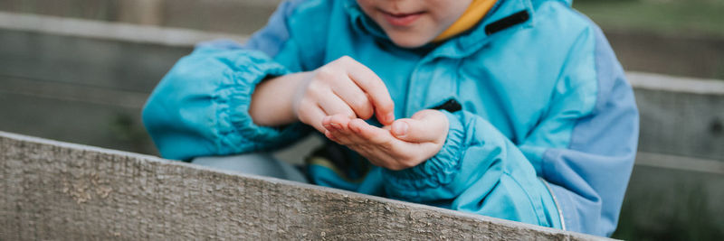 Spring planting seeding farm garden. little kid boy farmer gardener plants sow vegetable seeds soil