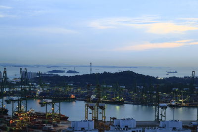 High angle view of harbor by city against sky during sunset