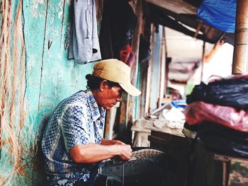 Side view of a man working on wood