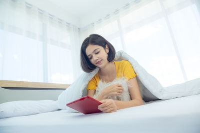 Young woman holding hands on bed