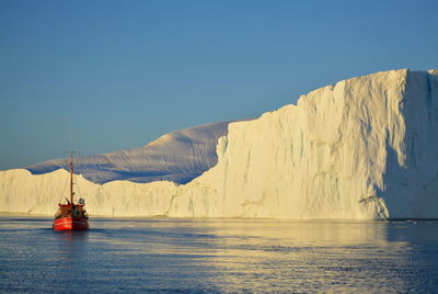 Great midnight sun boat trip in the arctic sea with big icebergs - greenland, disko bay, ilulissat 