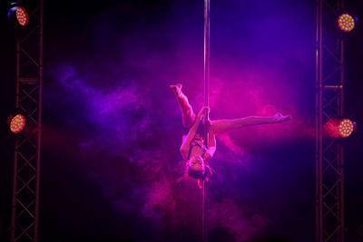 View of young woman pole dancing