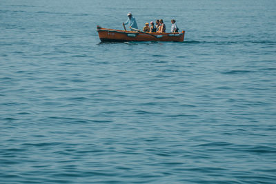 People in boat sailing on sea