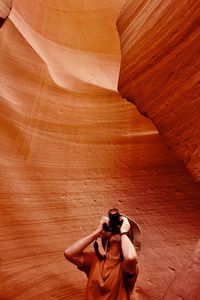 Woman photographing on rock