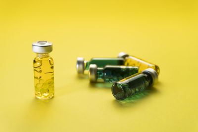 Close-up of glasses on table against yellow background