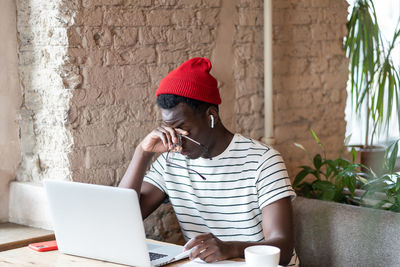 Man using mobile phone while sitting on table