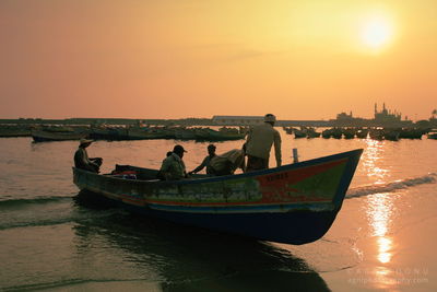 Boat sailing in sea at sunset