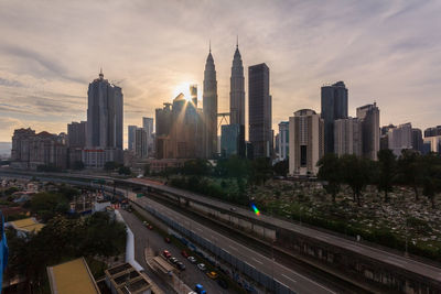 Aerial view of buildings in city against sky during sunset