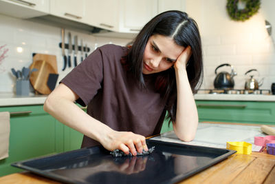 Side view of young woman sitting on table