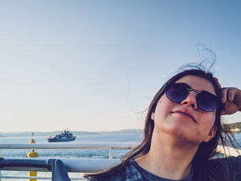 Portrait of woman wearing sunglasses against sea
