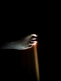 Close-up of human hand against black background