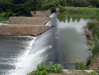 Scenic view of dam against trees
