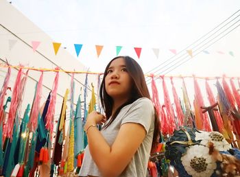 Young woman standing against multi colored wall