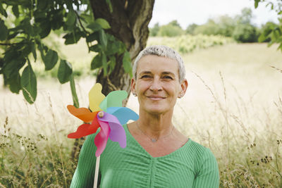 Portrait of young woman standing by plants on field