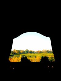 Scenic view of silhouette landscape against clear sky seen through window