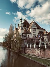 Buildings by river against sky in strasbourg, france