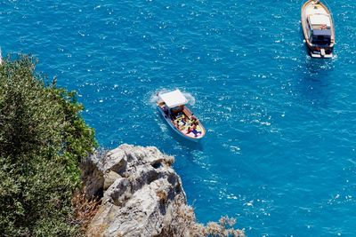 High angle view of people on rock by sea