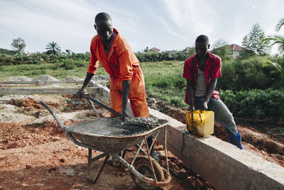 Rear view of men working in water