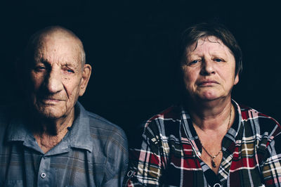 Portrait of woman and man against black background
