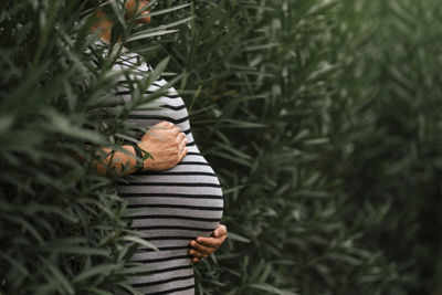 Low section of woman standing by plants