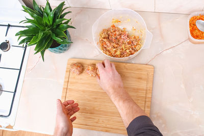 Cropped hand of person preparing food on table