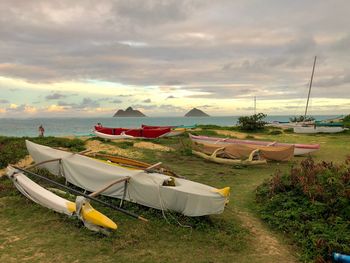 Boats moored on beach against sky