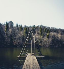 Pier over lake against clear sky