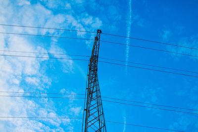 Low angle view of electricity pylon against blue sky