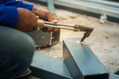 Midsection of man working on metal